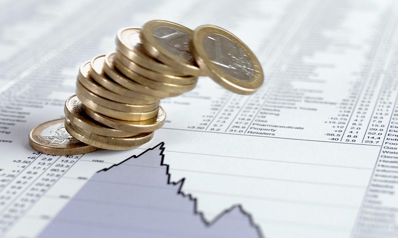 Ein fallender Stapel Euro-Münzen auf einer Börsen Zeitungsseite