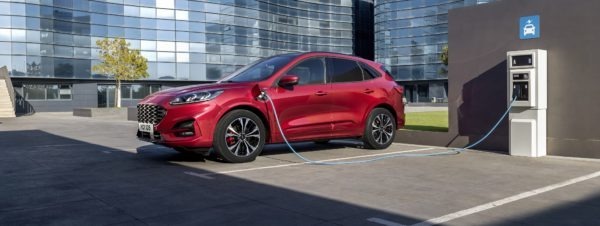 2019 Ford Kuga auf einem Parkplatz, dass gerade durch eine Elektro Tanksäule aufgeladen wird