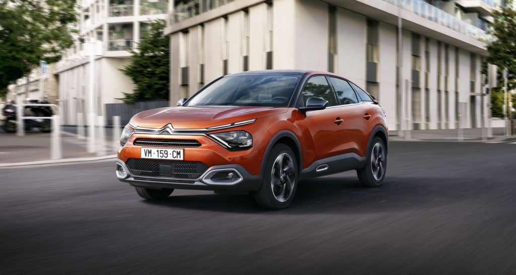 Citroën C4 auf der Straße mit Häusern im Hintergrund