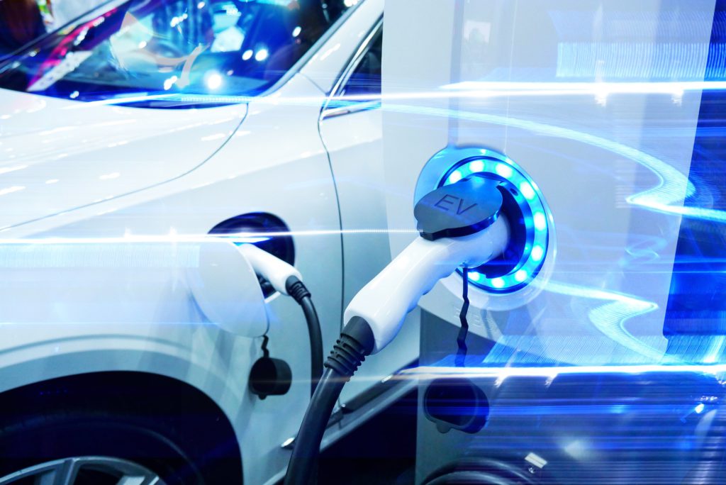 Weißes Elektroauto, das auf einer Ausstellung aufgeladen wird