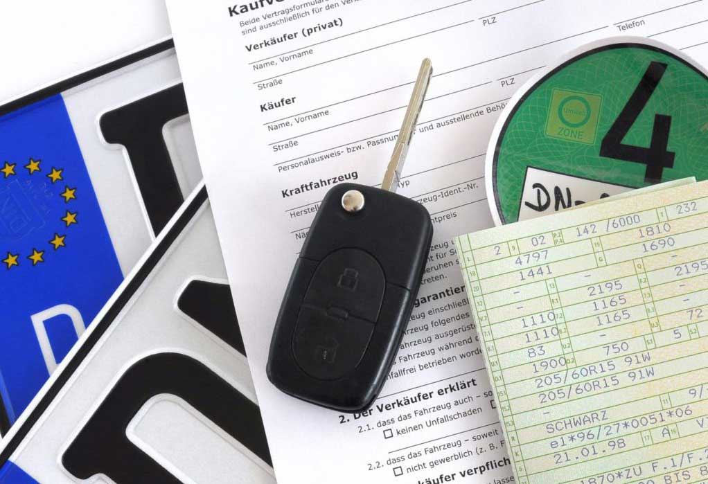 KFZ Schein mit Schlüssel vor einer KFZ-Anmeldung