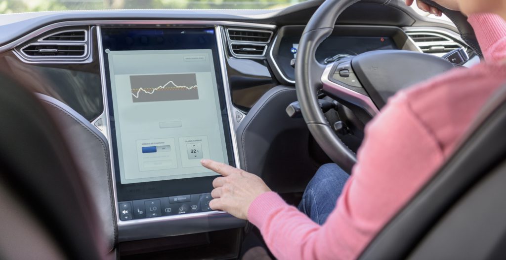 Eine Frau im Wagen, die einen Touchscreen bedient