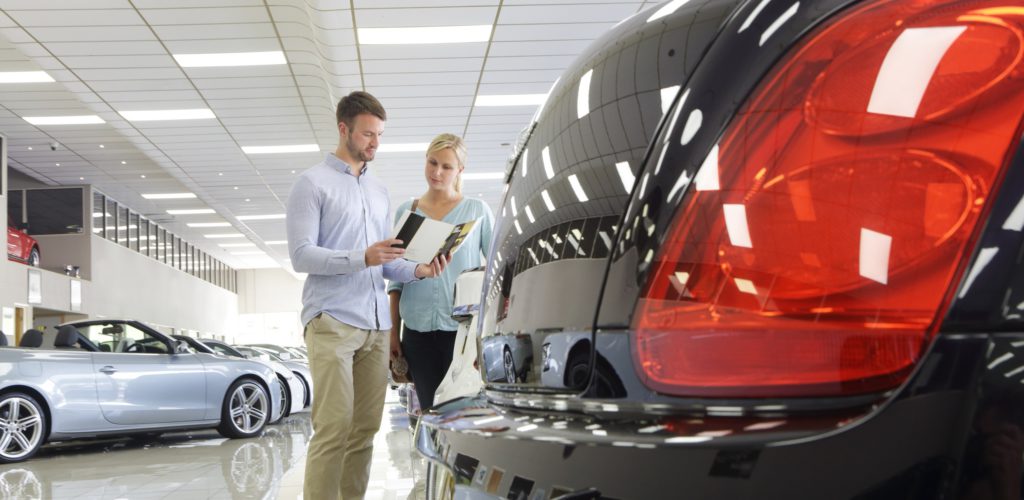 Verkäufer mit Kundin in einem Autohaus